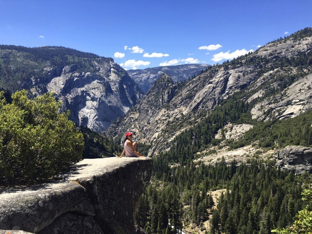 Mixte staff sitting on cliff with mountain view