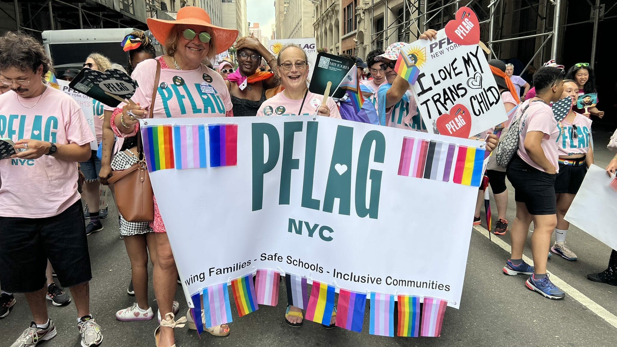 PFLAG members at a rally in New York City holding sign reading "PFLAG NYC"