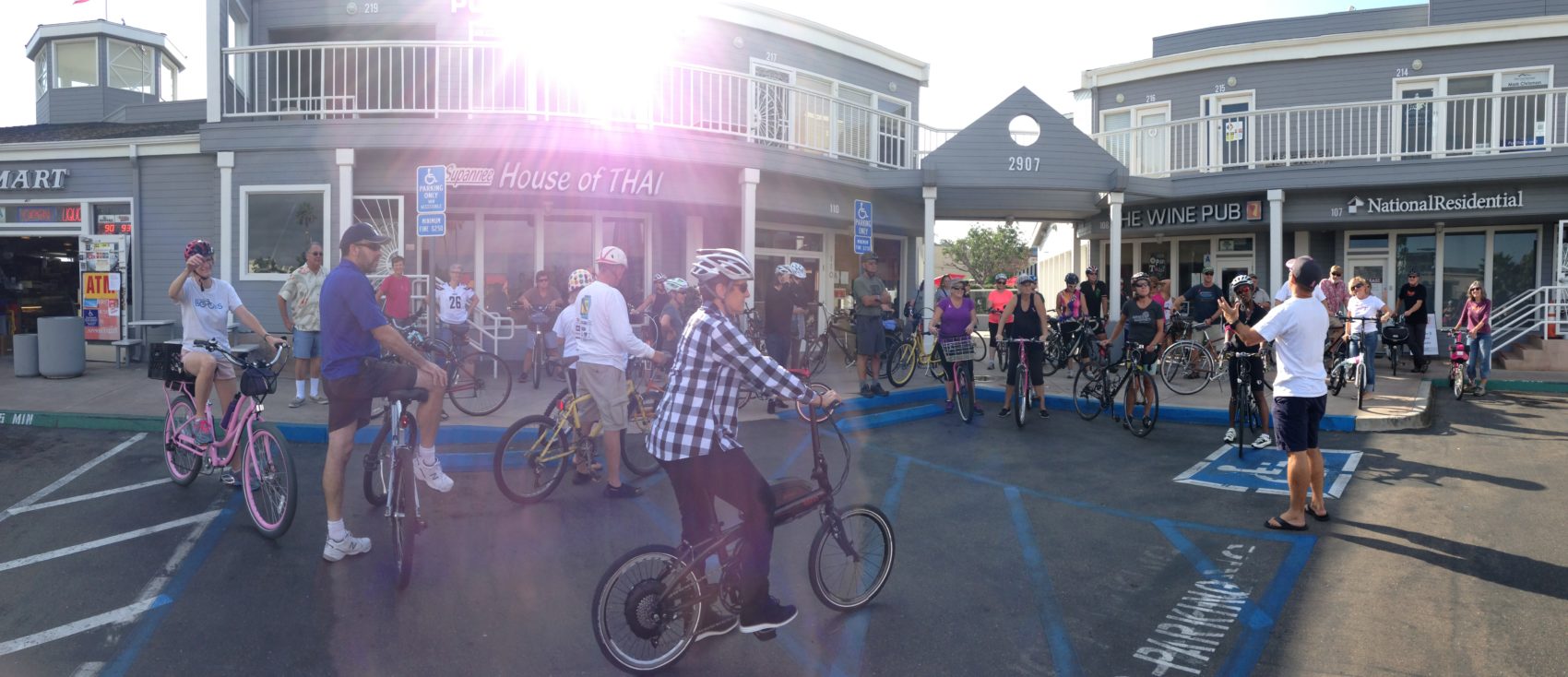 People riding bikes in front of The Wine Pub