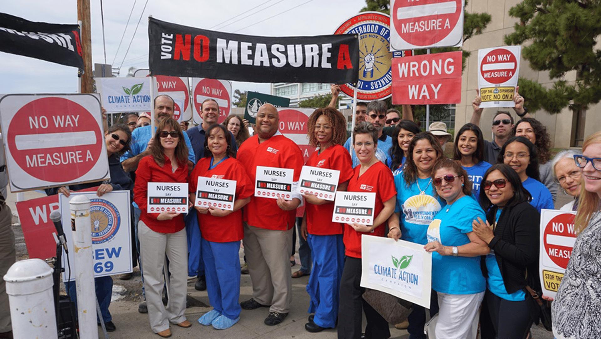 Quality of Life Coalition and other members protesting with signs reading "Vote NO Measure A"