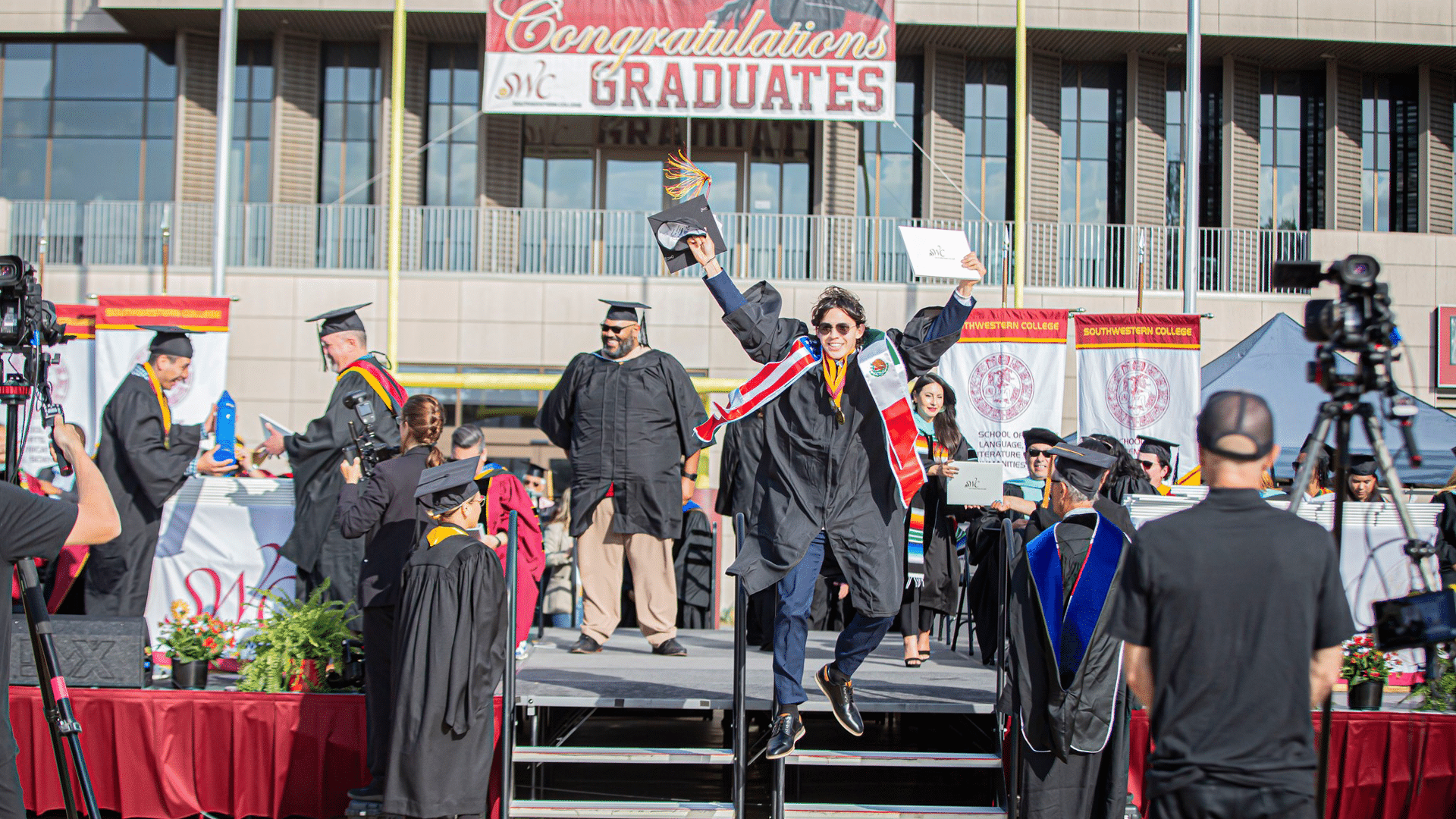 Graduate jumping for joy on stage at Southwestern College graduation