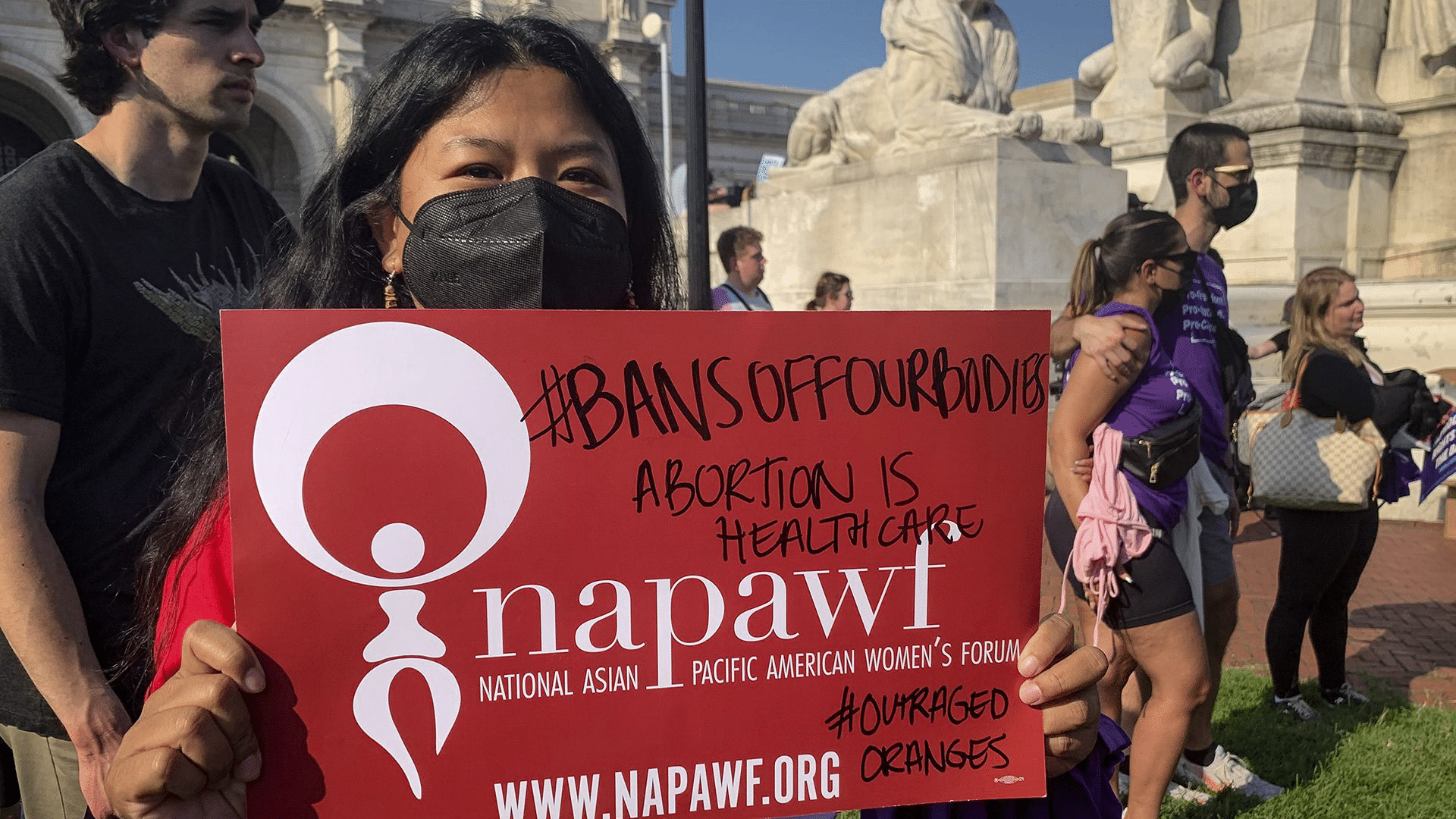 NAPAWF member holding sign reading "Ban Off Our Bodies"