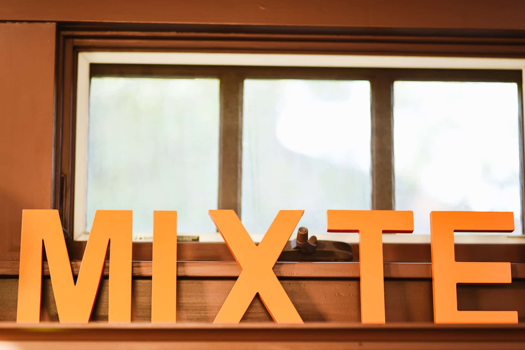 Decorative wooden letters spelling "Mixte" set in front of window