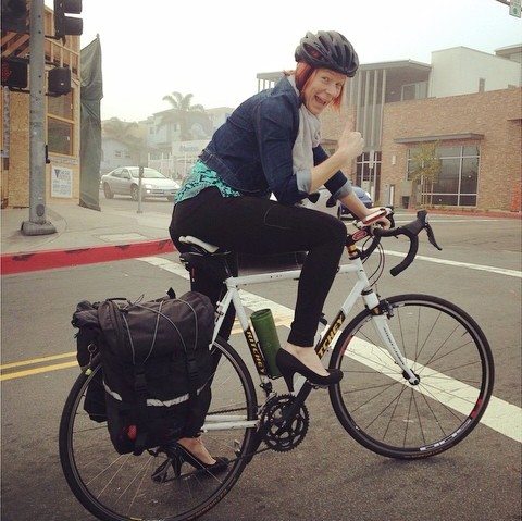 Jamie riding bike with a thumbs up