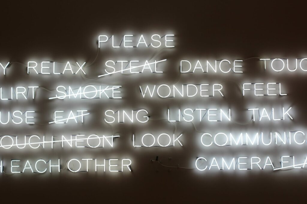 Words in neon light art piece